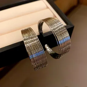 Detailed view of multi-layered metallic wire hoop earrings with a sleek minimalist design