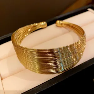 Detailed close-up showing the multi-strand texture of the gold metallic neck cuff.