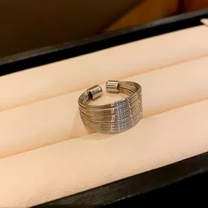Close-up of a minimalist multi-strand silver ring in a luxury velvet jewelry box.