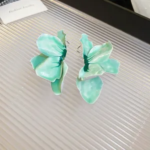 Macro view of mint green enamel flower earrings with intricate petal details