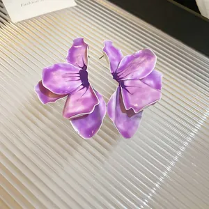 Detailed close-up of vibrant purple enamel flower earrings with silver needle studs.