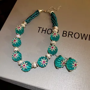 Dettaglio di set collana e orecchini vintage in resina verde su scatola testurizzata