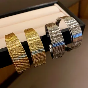 Detailed macro view of elegant multilayer metal hoop jewelry in gold and silver.