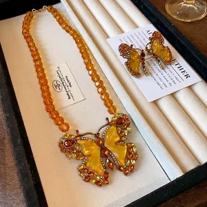 Parure collier papillon vintage avec perles en verre ambré et pendentif brillant