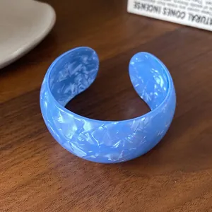 Chunky sky blue acrylic cuff bracelet with iridescent marbled texture and open design