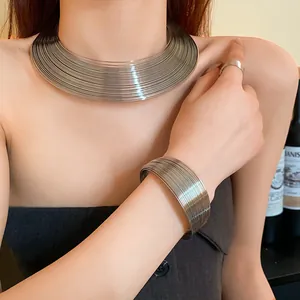 Detail of chic minimalist multi-layer metallic ring necklace and matching bracelet set