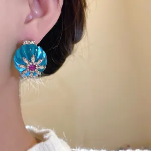 Primo piano di orecchini vintage in resina blu con accenti di strass brillanti