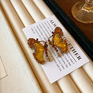 Vue détaillée d'un pendentif papillon vintage avec strass ambrés et ailes jaunes