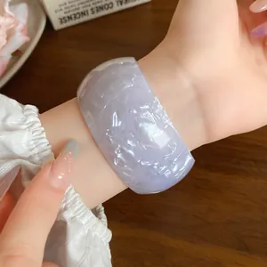Close-up of lavender iridescent acrylic wide bangle showing marbled texture on wrist