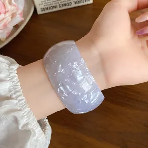 Detail showing iridescent lavender acrylic wide open bangle with marbled texture.
