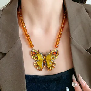 Gros plan détaillé d'un collier pendentif papillon ambre vintage avec des éclats de cristal
