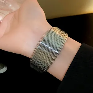 Close-up of a wide multi-layered silver metal cuff bracelet on wrist for fashion accessory
