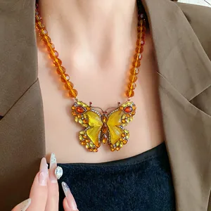 Collier pendentif papillon vintage avec perles en verre ambré et strass étincelants