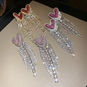 Primo piano di orecchini a nappa con cuore in zircone luccicante in vari colori.