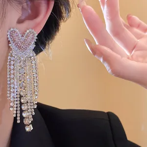 Dettaglio ravvicinato di eleganti orecchini a cuore in zircone con nappe a cascata
