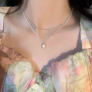 Primo piano di una collana d'argento a due strati con perla barocca sul modello