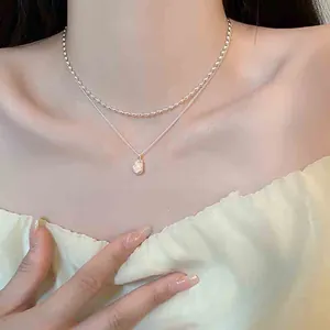 Primo piano della collana in argento a doppio strato con ciondolo di perla barocca