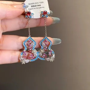 Detailed close-up of elegant hulu tassel earrings featuring turquoise and zircon flowers