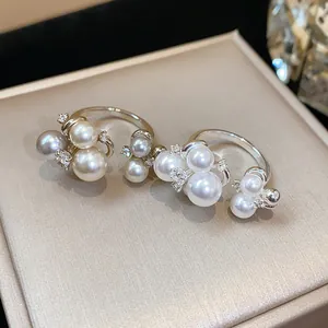 Close-up of French style pearl rings with zircon flowers and elegant luster.