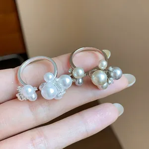 Detailed macro view of elegant French style cluster pearl and zircon flower rings