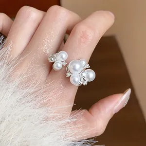 Close-up detail of an elegant French style flower ring with pearls and zircons on finger