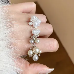 Detailed macro shot of elegant French style cluster pearl rings with zircon flower accents