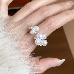 Detailed close-up showing an elegant French style pearl and zircon flower ring on a model hand