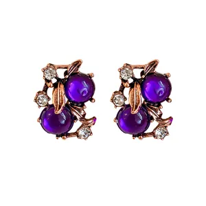 Vintage court style stud earrings featuring purple berry beads and rhinestone leaves