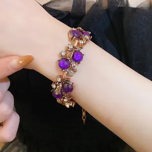 Close-up of vintage luxury gold-tone bracelet with purple stones and leaf details