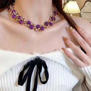 Detail of vintage palace style necklace with purple beads and crystal leaf motifs