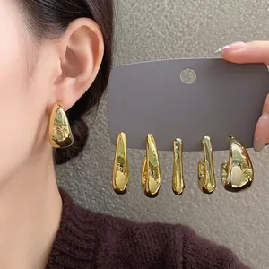 Elegant gold irregular geometric earrings shown on a model and display card