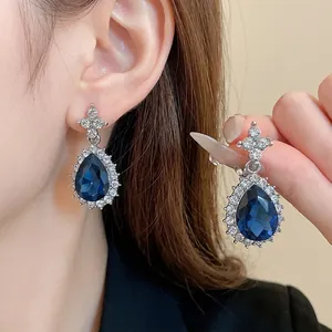 Boucles d'oreilles goutte bleues de luxe avec halo de strass et clou en forme de croix chic