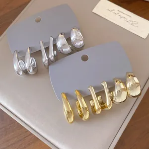 Close-up of irregular chunky geometric earring sets in polished gold and silver finishes