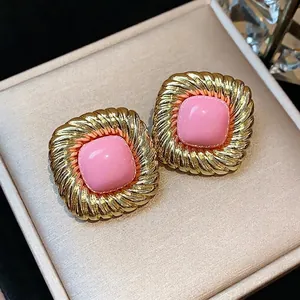 Elegant twisted square gold-plated stud earrings featuring a chic pink center decoration