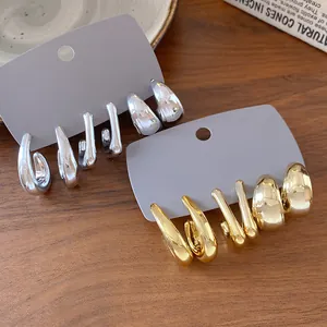 Detailed close-up view of minimalist irregular geometric earrings in gold and silver