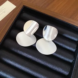 Close-up detail of vintage silver-tone brushed and polished metal round earrings