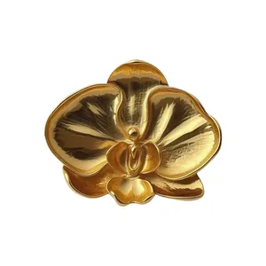 Elegant vintage gold orchid flower brooch with detailed metallic texture on white background.