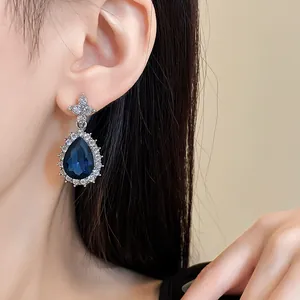 Vue détaillée de luxueuses boucles d'oreilles goutte d'eau avec pierre bleue et diamants