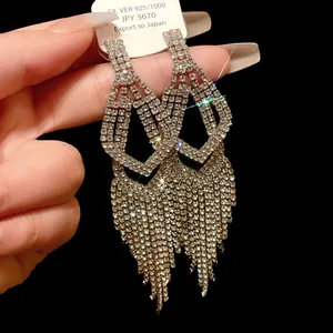 Gedetailleerd beeld van luxe lange kwastoorbellen met fonkelende strass en zilveren pinnen