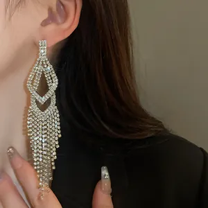 Gedetailleerd macrozicht van elegante lange fonkelende strass kwastjes oorbellen op een model