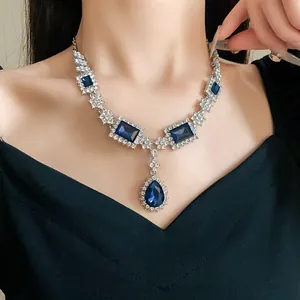 Collier élégant argenté avec des pendentifs en cristal bleu de forme carrée et de goutte