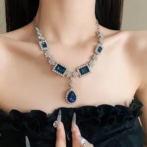 Gros plan d'un collier argenté élégant avec des pierres bleues sur un modèle.
