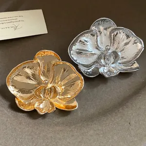 Detailed macro shot of vintage gold and silver orchid flower brooches for elegant women.