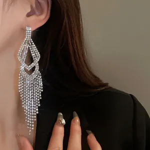 Elegante zilveren lange kwastoorbellen met fonkelende strasstenen gedragen door model