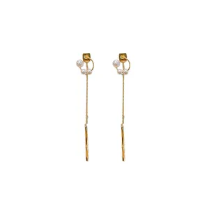 Elegant long gold tassel earrings featuring white pearls and polished metal bars