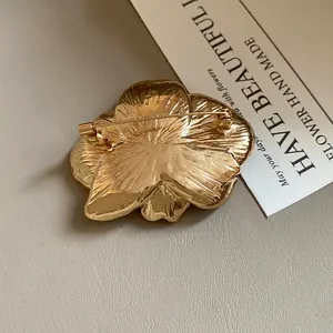 Detailed back view of vintage gold flower brooch featuring a secure safety pin clasp