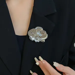 Elegant silver orchid flower brooch detail on a professional black blazer lapel.
