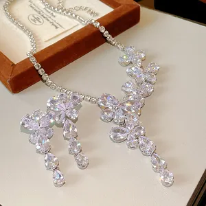Dettaglio macro di una collana di lusso in zircone con pendenti a farfalla e fiori eleganti