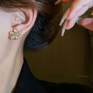 Detailed macro view of crystal flower stud earring worn on ear showing sparkling stones