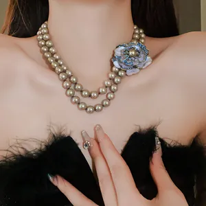 Detail of vintage French style double-strand pearl necklace with blue crystal flower ornament